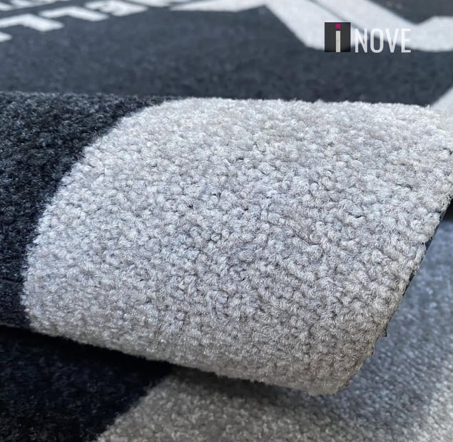 Tapete de nylon cinza enrolado mostrando a superfície têxtil Tapete de nylon cinza enrolado mostrando a superfície têxtil