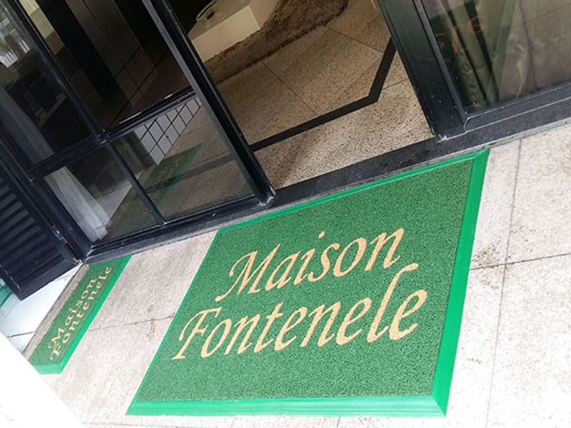 Tapete verde personalizado 'Maison Fontenele' na entrada externa do edifício Tapete verde personalizado 'Maison Fontenele' na entrada externa do edifício