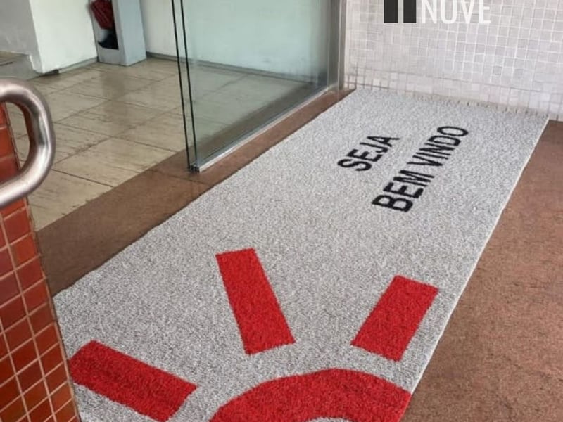 Capacho de fibra de coco com moldura vermelha e o logotipo ABIC