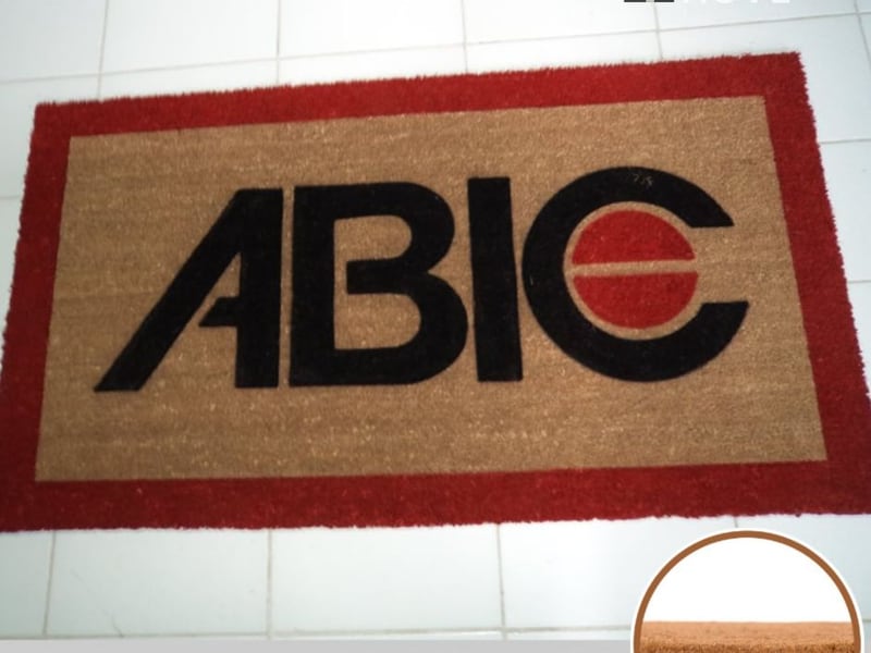 Capacho de fibra de coco com borda vermelha identificando a sigla ABIC Capacho de fibra de coco com borda vermelha identificando a sigla ABIC