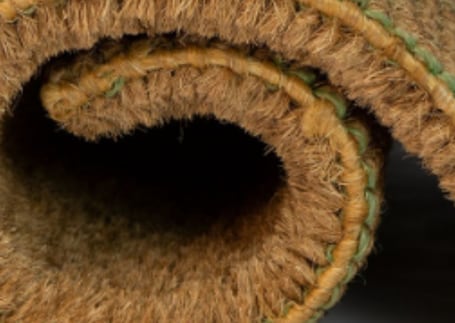 Capacho de fibra de coco enrolado mostrando a espessura das fibras