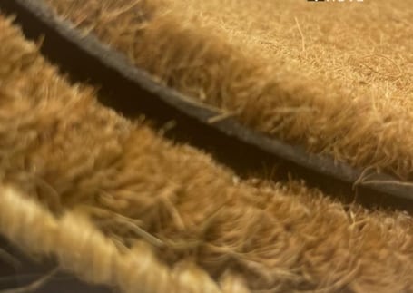 Detalhe das fibras naturais na borda de um capacho de fibra de coco
