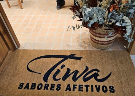 Capacho de fibra de coco 'Tiwa Sabores Afetivos' na entrada do estabelecimento Capacho de fibra de coco 'Tiwa Sabores Afetivos' na entrada do estabelecimento