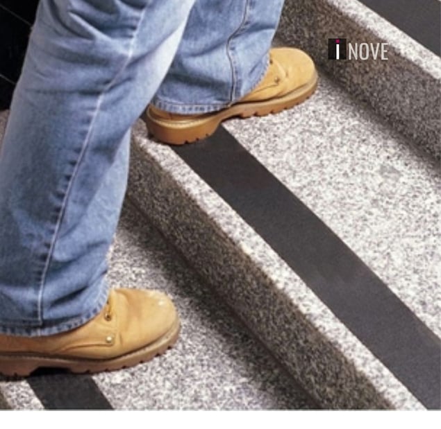 Pessoa de botas subindo escada com fita antiderrapante preta nos degraus Pessoa de botas subindo escada com fita antiderrapante preta nos degraus