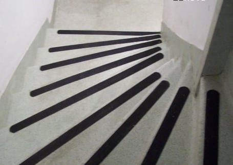 Tiras de fita antiderrapante preta aplicadas em uma escada Tiras de fita antiderrapante preta aplicadas em uma escada