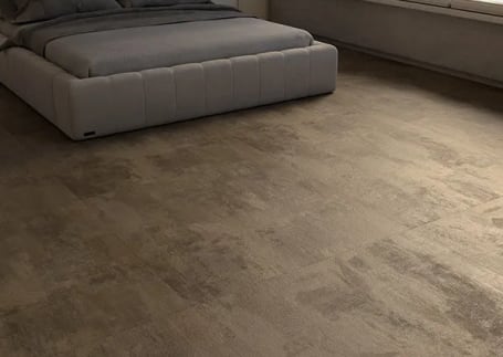 Quarto com piso vinílico amadeirado escuro e cama cinza