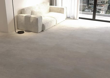 Sala de estar com piso vinílico cinza claro e sofá branco