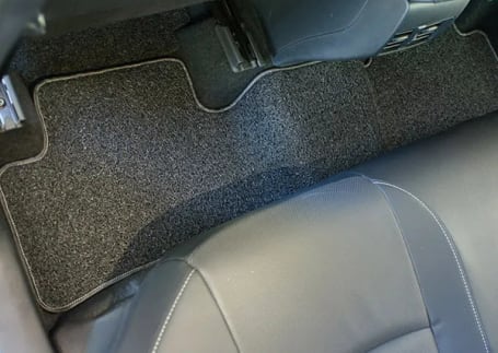 Tapete automotivo cinza-escuro no assoalho traseiro do carro