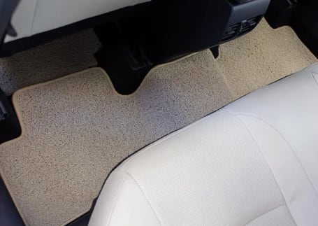 Tapete automotivo bege na área traseira do veículo