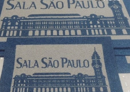 Tapetes azuis da Sala São Paulo com ilustração do prédio