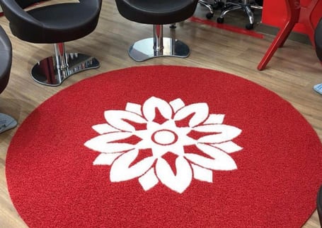 Tapete redondo vermelho com mandala branca em um salão Tapete redondo vermelho com mandala branca em um salão