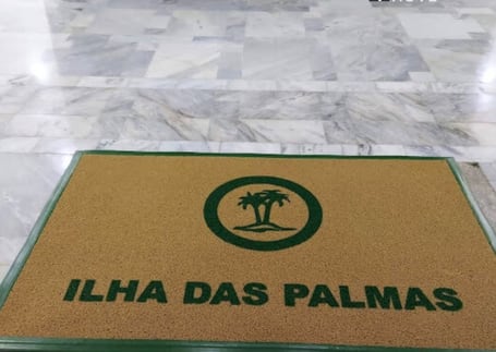 Tapete com perfil verde 'Ilha das Palmas' na entrada de mármore