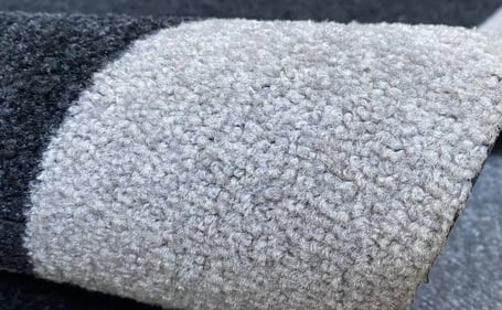 Tapete de nylon cinza enrolado mostrando a superfície têxtil Tapete de nylon cinza enrolado mostrando a superfície têxtil