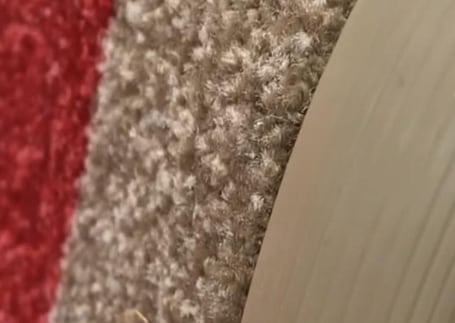 Close da superfície têxtil de um tapete de nylon bege enrolado