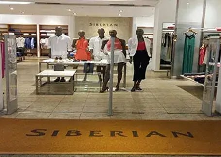 Tapete emborrachado amarelo personalizado na entrada de loja de roupas