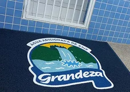 Tapete emborrachado azul com logo de marca de água mineral em portaria Tapete emborrachado azul com logo de marca de água mineral em portaria