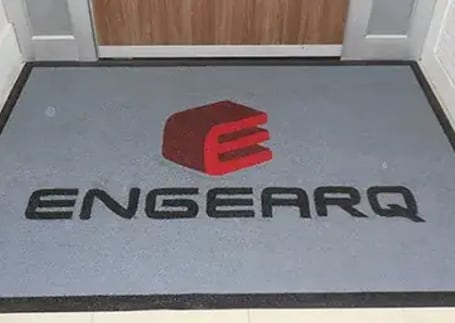 Tapete emborrachado cinza-claro com logo vermelho de empresa de engenharia