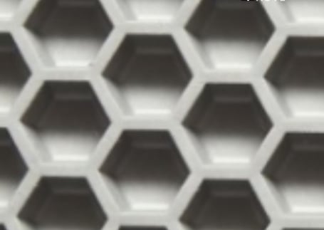 Close da superfície hexagonal vazada de um tapete para área úmida