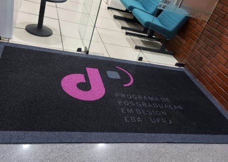 Tapete cinza com logo de empresa em recepção corporativa
