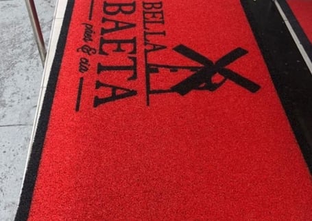 Tapete vermelho da Bella Baeta com logo de navalha e tesoura Tapete vermelho da Bella Baeta com logo de navalha e tesoura
