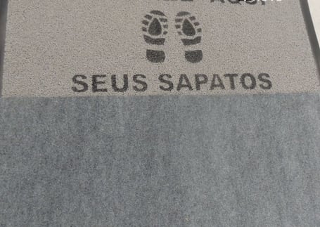 Tapete sanitizante cinza 'Higienize aqui seus sapatos' com pegadas Tapete sanitizante cinza 'Higienize aqui seus sapatos' com pegadas