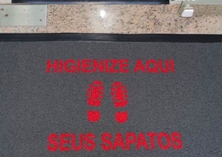 Tapete sanitizante escuro 'Higienize aqui seus sapatos' em vermelho